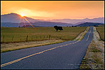 Photo: Golden sunrise light over long straight two lane country road and rolling hills in Spring, Santa Ynez Valley, California