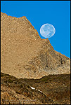 Photo: Full moon setting over rock outcrop along the Sierra Crest, near Tioga Pass, California