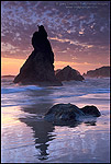 Photo: Clouds at sunset over jagged coastal rocks reflection in ocean waves breaking on Bandon State Beach, Oregon