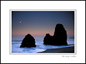 Moonset at dawm over rocks and ocean, Rodeo Beach, Marin County Coast, California