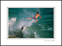 Boy flying through air after hit by wave while skimboarding on beach, Balboa Island, Newport Beach, California