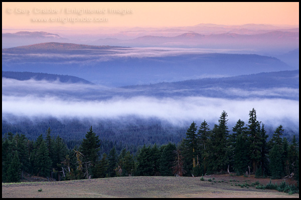 Photo: Sunrise light on hills over misty cloud, trees, and forest, Crater Lake National Park, Oregon