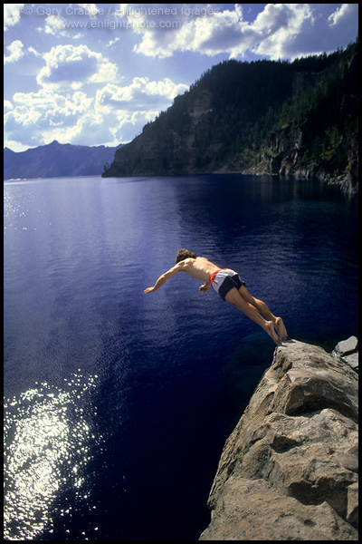 Picture: Tourist taking a dive off rock cliff into clear blue water of Crater Lake at Cleetwood Cove, Crater Lake National Park, Oregon