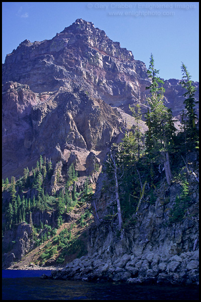 Photo: Steep and rugged volcanic crater walls rising above Crater Lake, Crater Lake National Park, Oregon