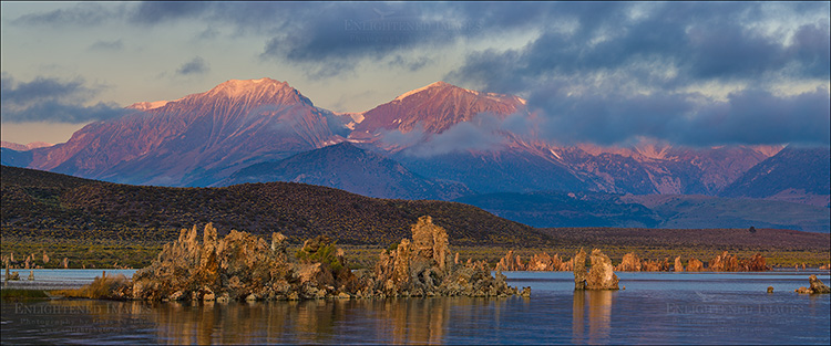 Panoramic Photo: Alpenglow on mountains at sunrise seen through breaking clouds over Mono Lake, Eastern Sierra, California