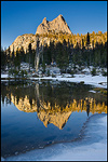 Picture: Sunset light on Cathedral Peak reflected in a snow-lined alpine tarn, Yosemite National Park, California