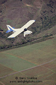 Small single engine fixed wing plane (Maule) over vineyards in the Napa Valley, California