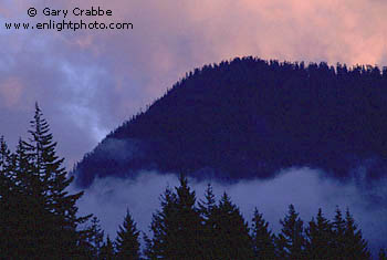 Evening light on storm clouds over coastal mountain peak above Howe Sound, near Squamish, British Columbia, Canada