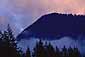 Evening light on storm clouds over coastal mountain peak above Howe Sound, near Squamish, British Columbia, Canada