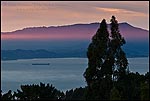 Picture: Ray of red sunlight at sunset shooting over San Francisco Bay from the Berkeley Hills, California