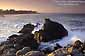 Waves crash on rocks at sunset in Monterey Bay, near Pacific Grove, California