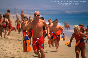 Kids running on sand beach in Junior Lifeguard Summer education camp, Balboa Island, Newport Beach, Orange County Coast, Southern California