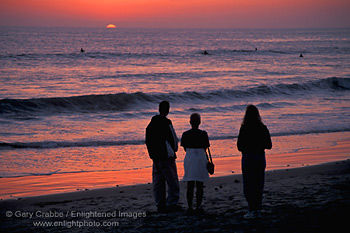 Family watching the sunset over the Pacific Ocean from beach at Carlsbad, San Diego County Coast, California