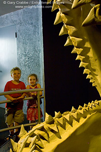 Kids pose in front of ancient giant dinosaur shark tooth jaws at SeaWorld, near San Diego, California