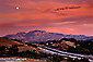 Full moon rising through red clouds during a stormy sunset over Mount Diablo, Lafayette, Contra Costa County, San Francisco Bay Area, California