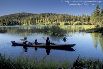 Family paddling in Manzanita Lake in homemade wooden kayak, Lassen Volcanic National Park, California; Stock Photo photography picture image photograph fine art decor print wall mural gallery