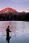 Lone fisherman fishing in Manzanita Lake at sunset below Mount Lassen, Lassen Volcanic National Park, California