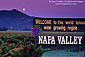 Full moon setting at dawn over vineyard and welcome sign at entrance to the Napa Valley, Napa, California