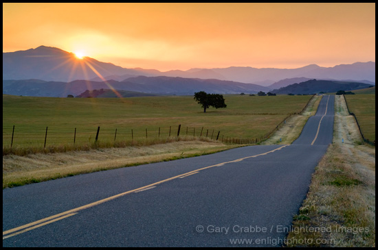 Photo:  Golden sunrise light over long straight two lane country road and rolling hills in Spring, Santa Ynez Valley, California