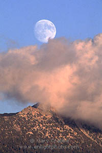 Full moon rising through storm clouds over Mount Clark, Yosemite National Park, California