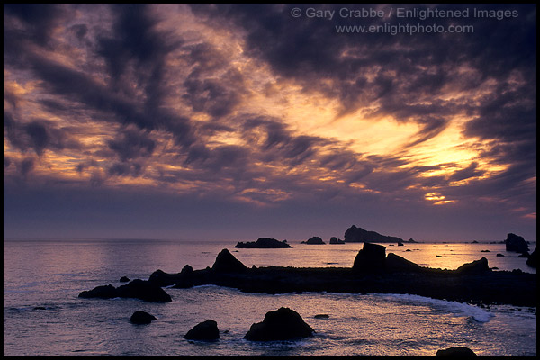 Photo: Sunset and clouds over coastal rocks and ocean at Cresent City, California