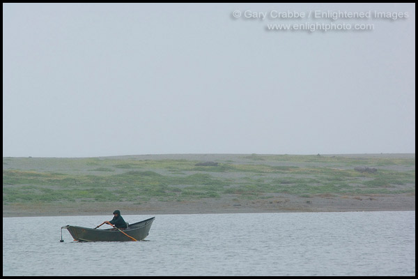 Photo: Fisherman in small dory boat in the rain and fog on Big Lagoon, Humboldt Lagoons State Park, California