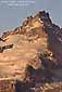 Golden light of sunrise on glacier-covered lava buttress high on Mount Rainier volcano, Mount Rainier National Park, Washington