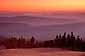 Sunset over trees and forested rolling hills, from the rim of Crater Lake, Crater Lake National Park, Oregon