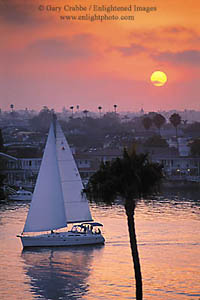 Catalina Sailboat leaving Newport Harbor at sunset, Newport Beach, California