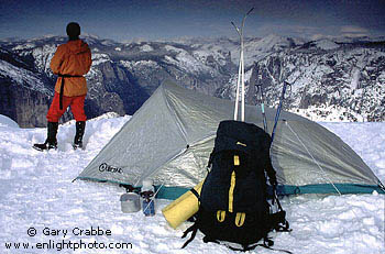 Cross country skier's winter tent camp overlooking snow covered mountains, above Yosemite Valley, Yosemite National Park, California