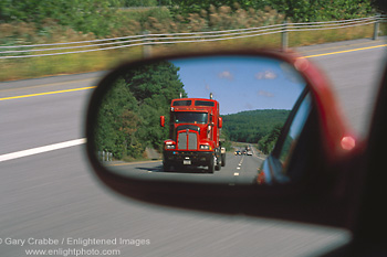 Photo: Red tractor trailer semi truck rig in rearview mirror on highway, Upstate New York