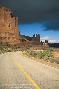 Image: Storm clouds over road bend and red sandstone cliffs, Arches National Park, Utah
