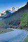 Snow covered mountain peak over twisting mountain road and aspen trees, Maroon Bells Wilderness, near Aspen, Rocky Mountains, Colorado