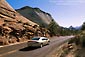 Image: Car driving on road below Checkerboard Mesa, Zion National Park, Utah