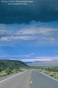 Photo: Storm clouds over two lane desert highway road leading into Death Valley, Death Valley National Park, California