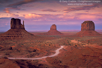 Image: Dirt road through desert under red sky sunset, Monument Valley, Arizona
