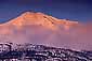 Alpenglow at sunset on Mount Shasta volcano after a winter storm, near Weed, Siskiyou County, Northern California