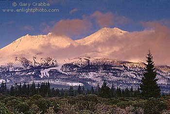 Sunset light on Mount Shasta volcano during a winter storm, near Weed, Siskiyou County, Northern California