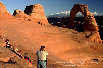 Tourists gather at sunset in the Delicate Arch ampitheater, Arches National Park, Utah