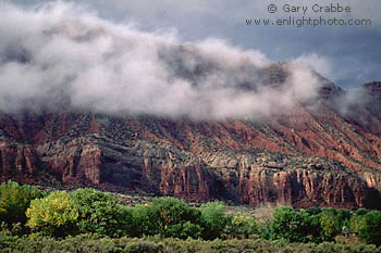 Fall storm clouds shroud red rock cliffs above Castle Valley, Utah