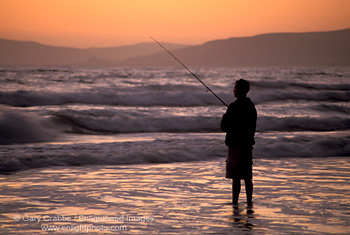 Young man surf fishing at sunset, Morro Strand State Beach, Central Coast, California; Stock Photo photography picture image photograph fine art decor print wall mural gallery