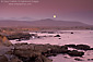 Full moon rising in purple evening sky over coastal hills, near San Simeon, Central Coast, California