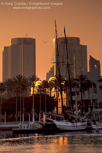 ailing ship docked below city high rise office buildings in downtown at sunset, Long Beach Harbor, California