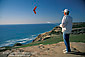 Man flying radio contolled glider from bluff overlooking the Pacific Ocean, near La Jolla, San Diego County Coast, California
