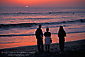 Family watching the sunset over the Pacific Ocean from beach at Carlsbad, San Diego County Coast, California
