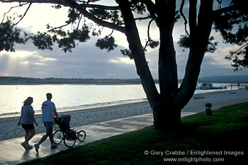 Couple walking on path with baby stroller along Mission Bay, San Diego County Coast, California