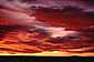 Bright red altostratus clouds at sunset over the Arizona desert