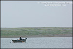 Picture: Fisherman in small dory boat in the rain and fog on Big Lagoon, Humboldt Lagoons State Park, California