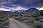 Stormy sunset over dirt road below the high mountain peaks of the Eastern Sierra, near Bishop, Inyo County, California