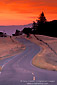 Red clouds over twisting two lane rural country road through hills at sunrise, near Orr Springs, Mendocino County, California